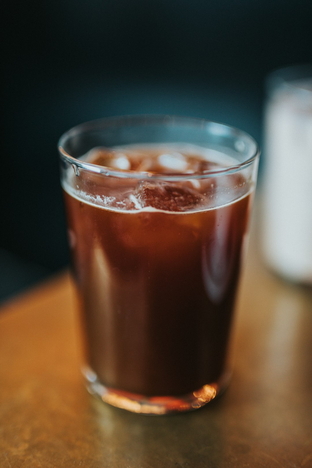 macro photography of clear glass filled with brown liquid