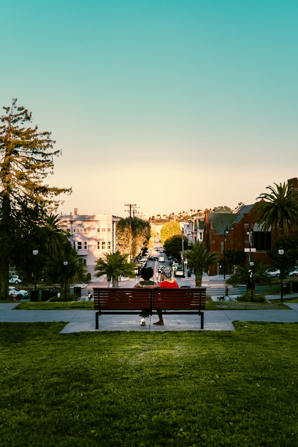 a person sitting on a bench in a park