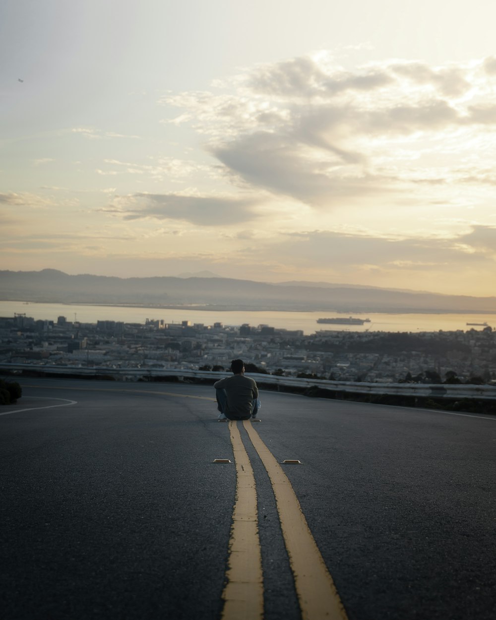 man sitting on concrete road