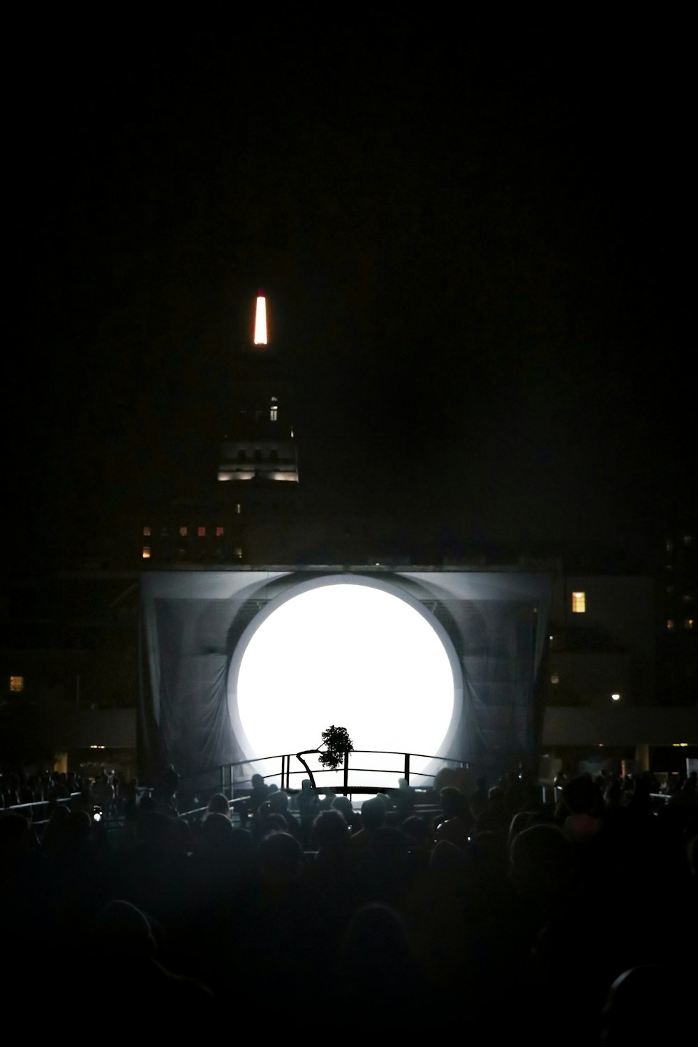 Multitud frente al escenario iluminado por la noche