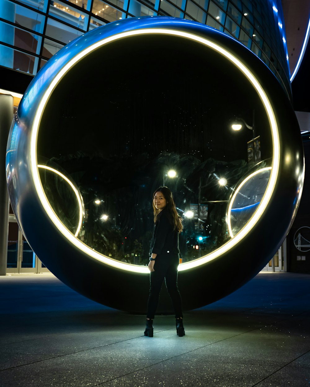 standing woman in front of circle structure