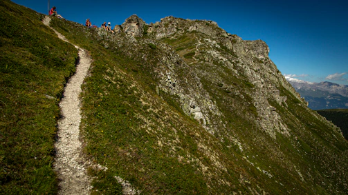 Hikers enjoying a sunlit mountain trail with panoramic views.