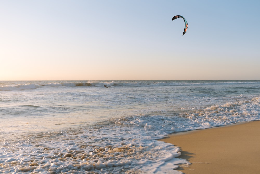 man paragliding on beach