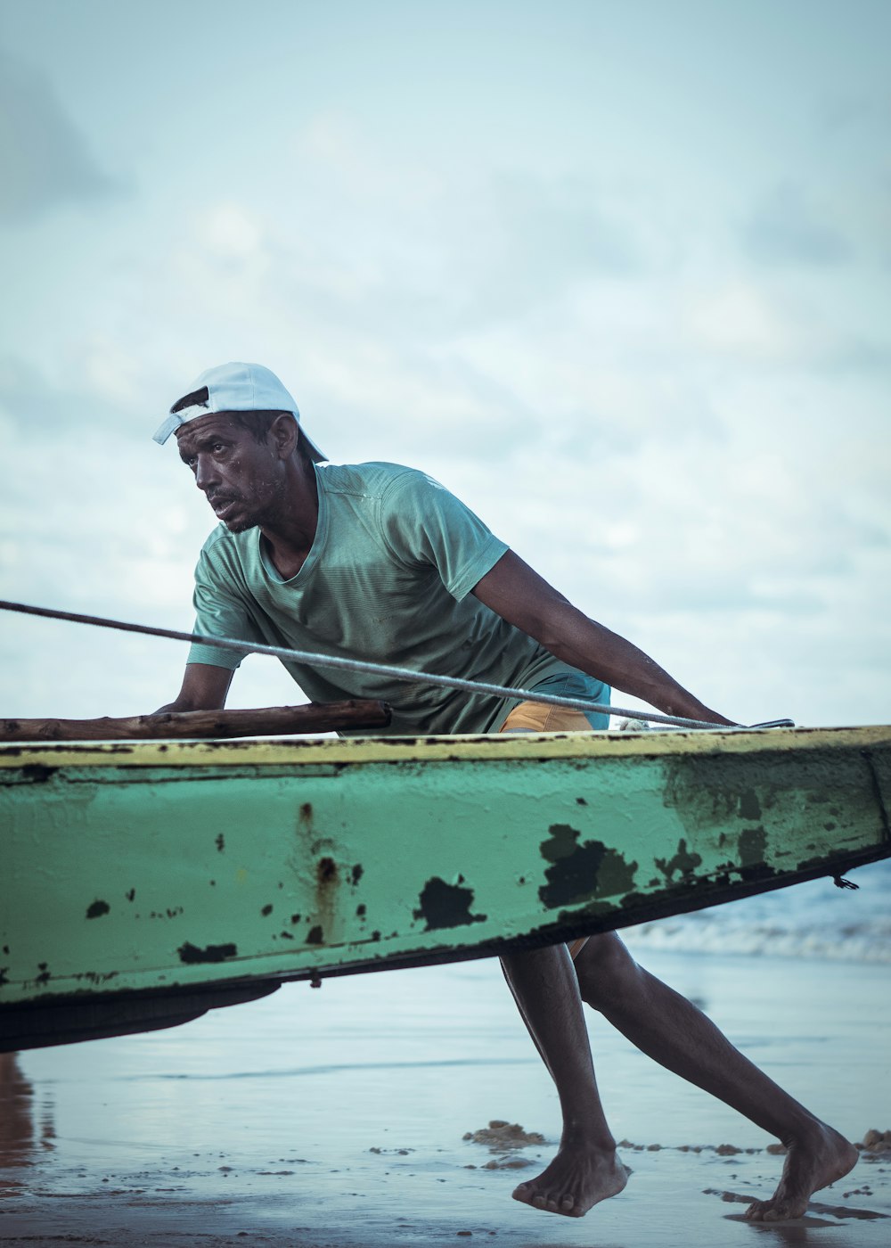 man pushing green boat