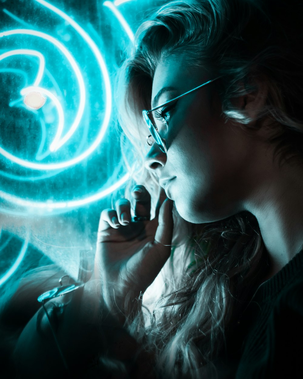 woman wearing sunglasses near blue neon lights