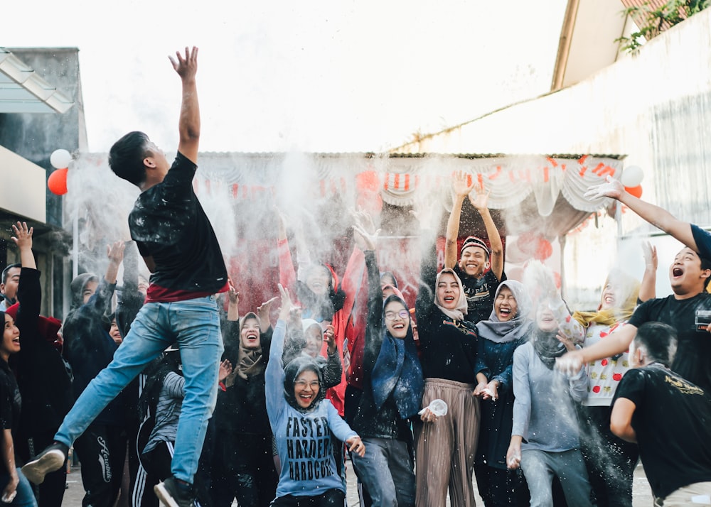 man in black shirt jumping beside group of people