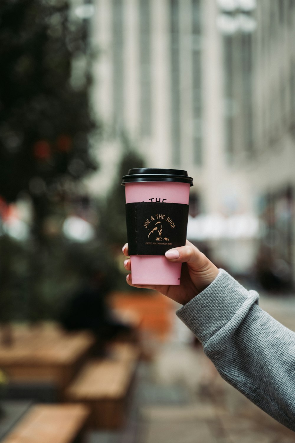 Persona sosteniendo una taza de café rosa y blanco