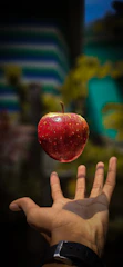 red apple floating over a man&amp;amp;amp;amp;#x27;s hand