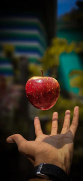 red apple floating over a man&amp;amp;amp;amp;#x27;s hand