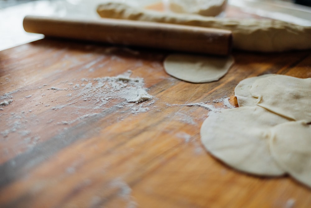 a wooden table topped with uncooked dough