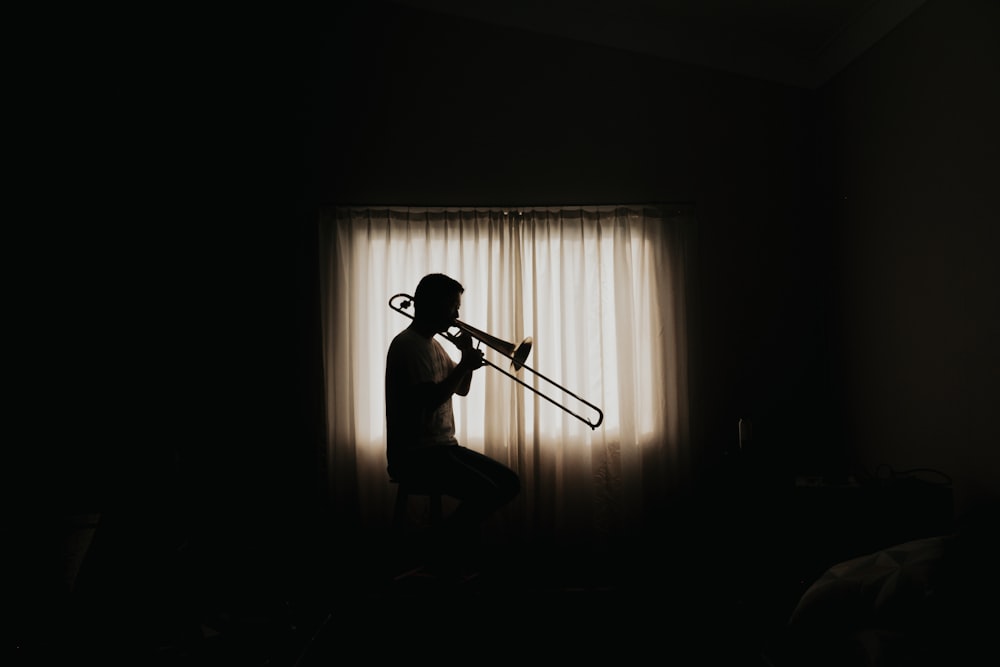 hombre jugando al viento instrumend dentro de la habitación