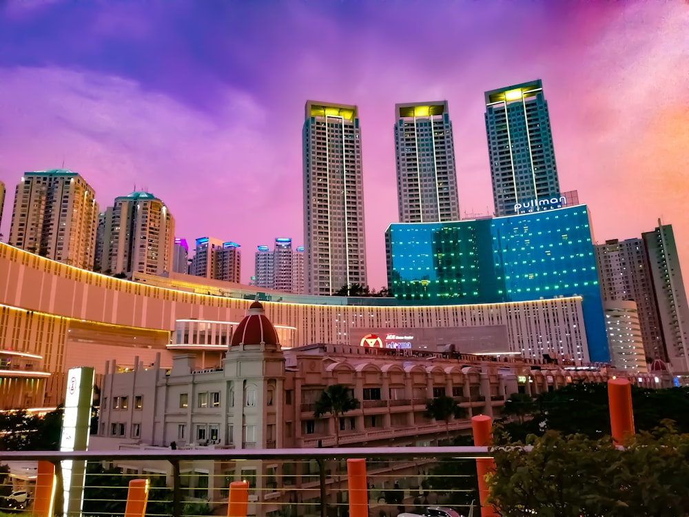 city with high-rise buildings under blue and orange sky during night time