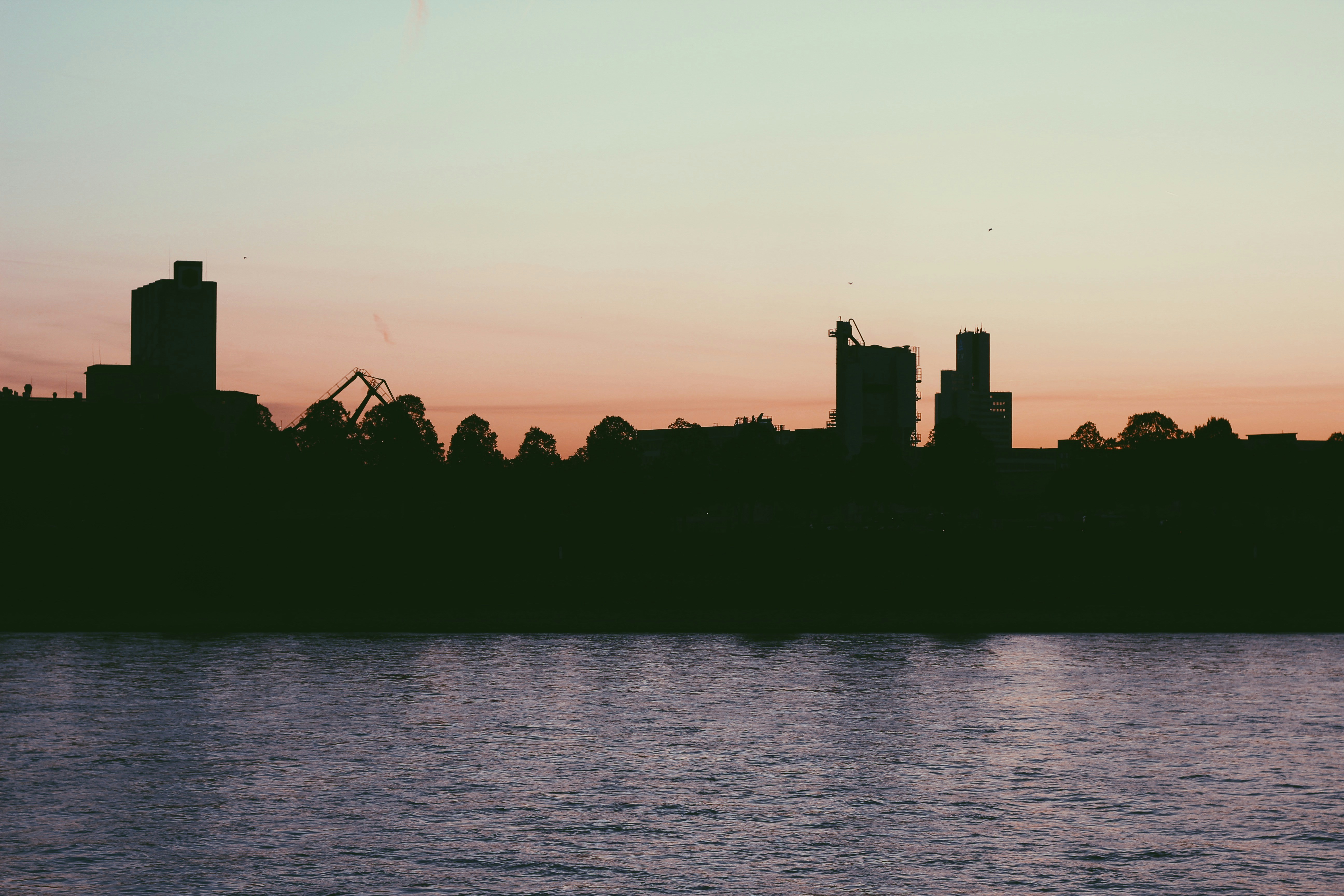 Silhouette von Gebäuden neben Gewässer