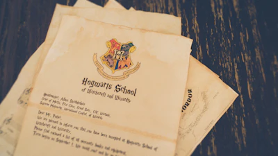 A vintage-looking letter with the Hogwarts School of Witchcraft and Wizardry crest. The letter appears aged, with a parchment-like texture and includes a message addressed to Mr. Potter. Some details are visible, such as the school name and a reference to Albus Dumbledore.