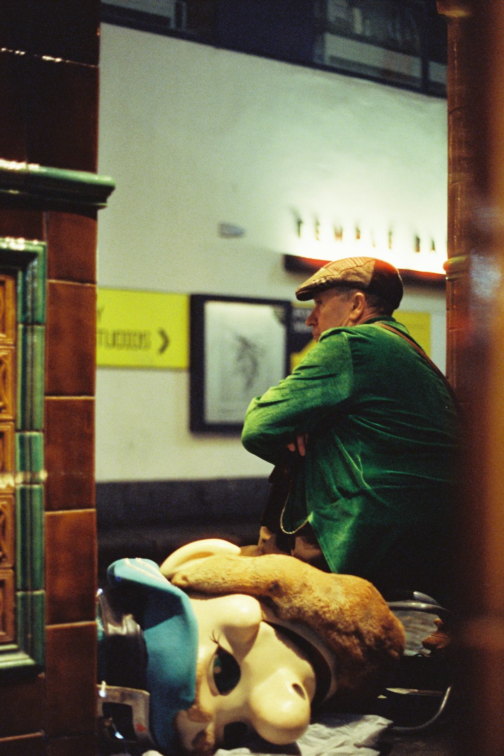 man wearing green jacket and beige cap