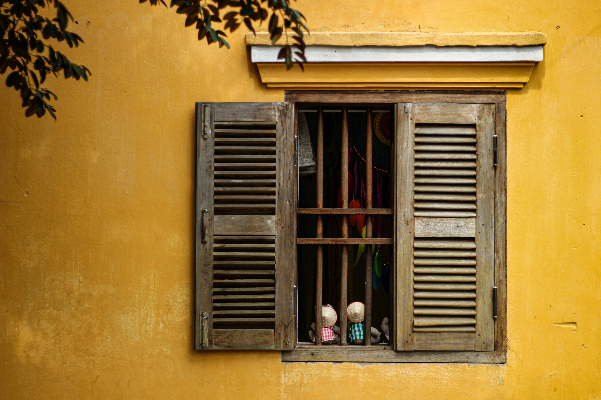 Yellow wall, opened window, Hoi An, Photo by Thanti Riess / Unsplash