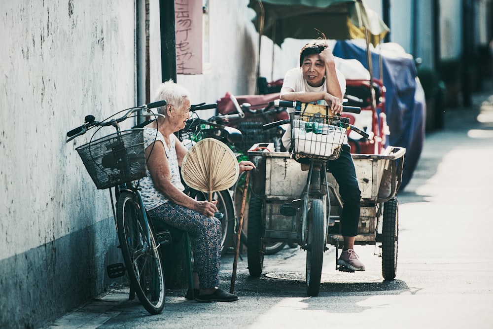 woman sitting bicycle while talking to man