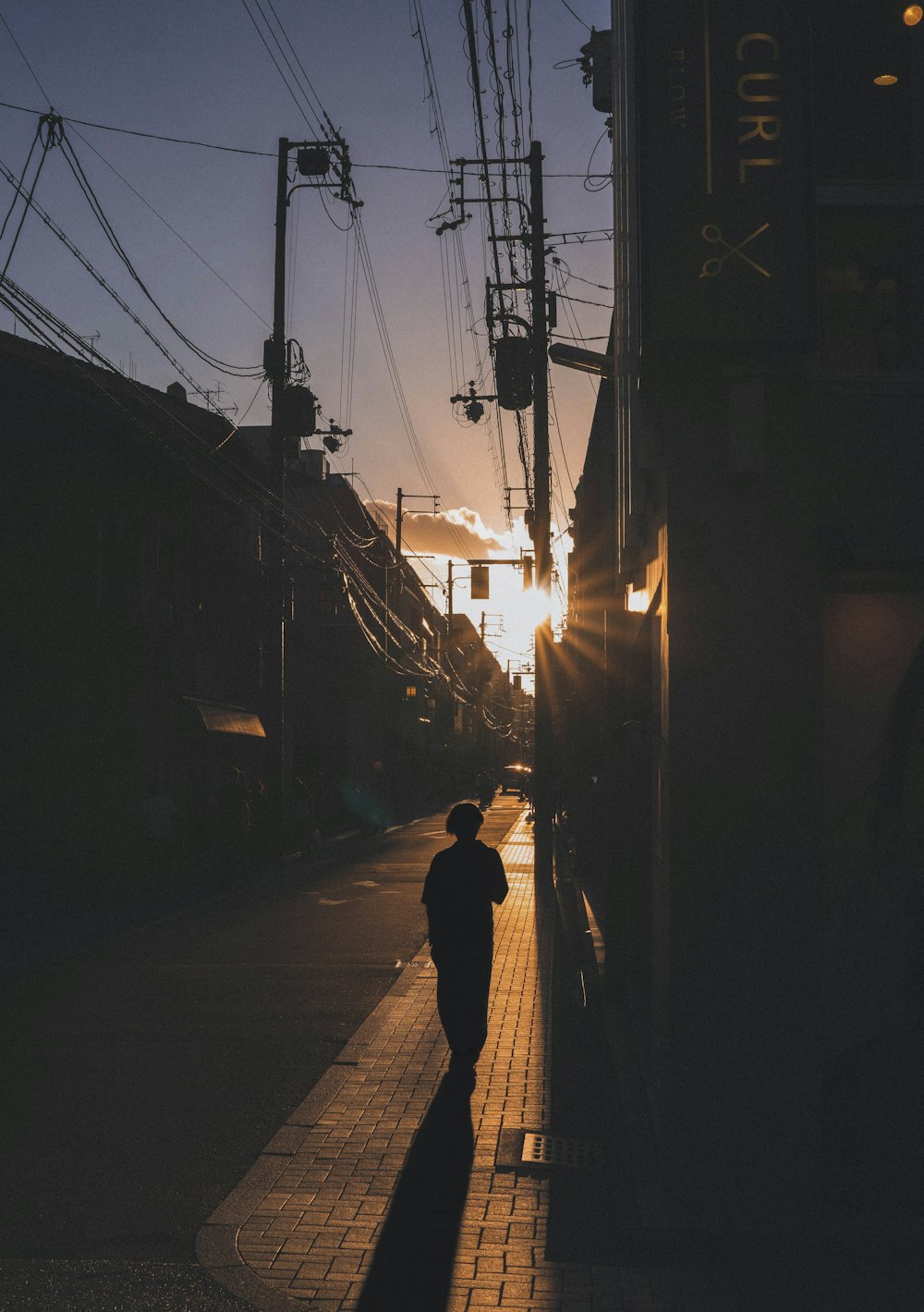 a person walking down a sidewalk next to a train