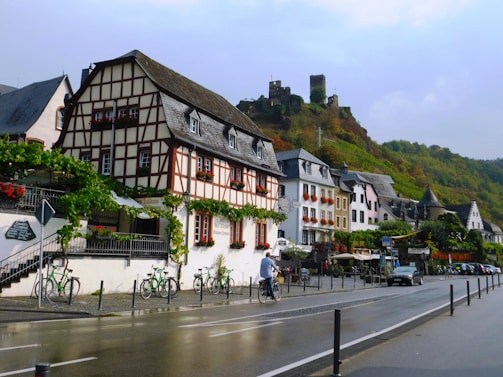 Cyclists pedaling through a quaint village with cobblestone streets and blooming gardens.