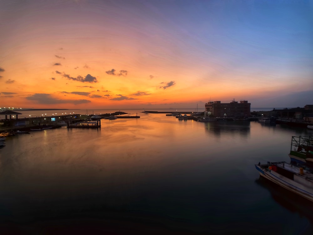 a sunset over a body of water with boats in it