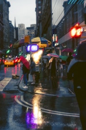 A misty Chennai street scene during monsoon, with colorful umbrellas and wet pavements reflecting city lights.