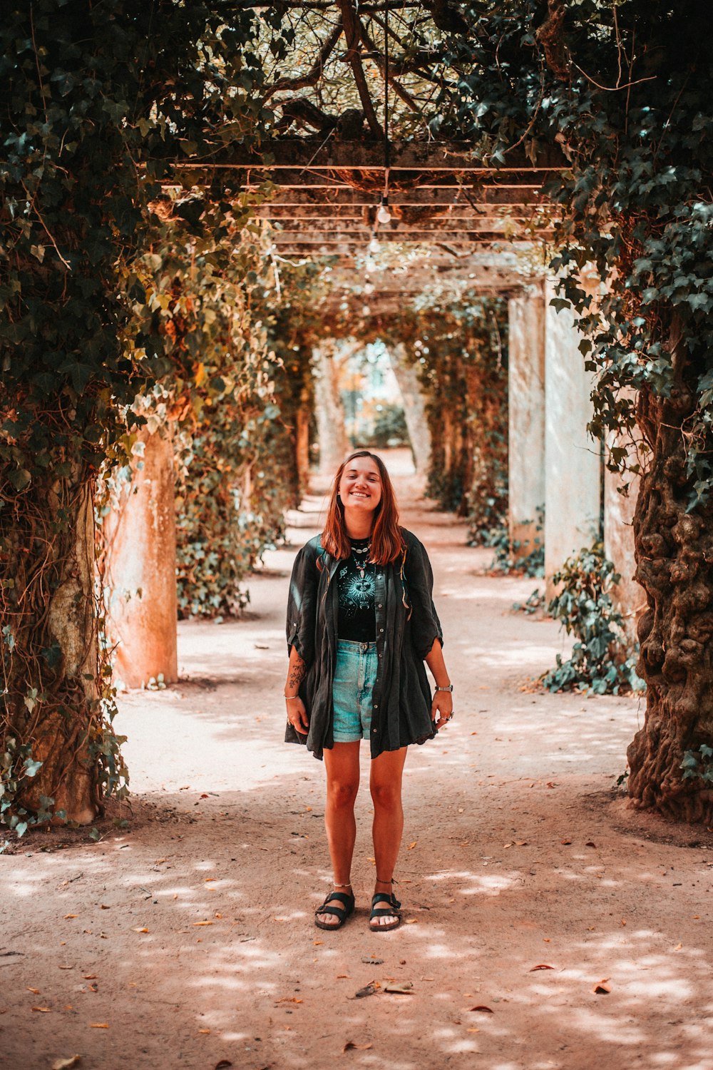 woman standing in tunnel of plants