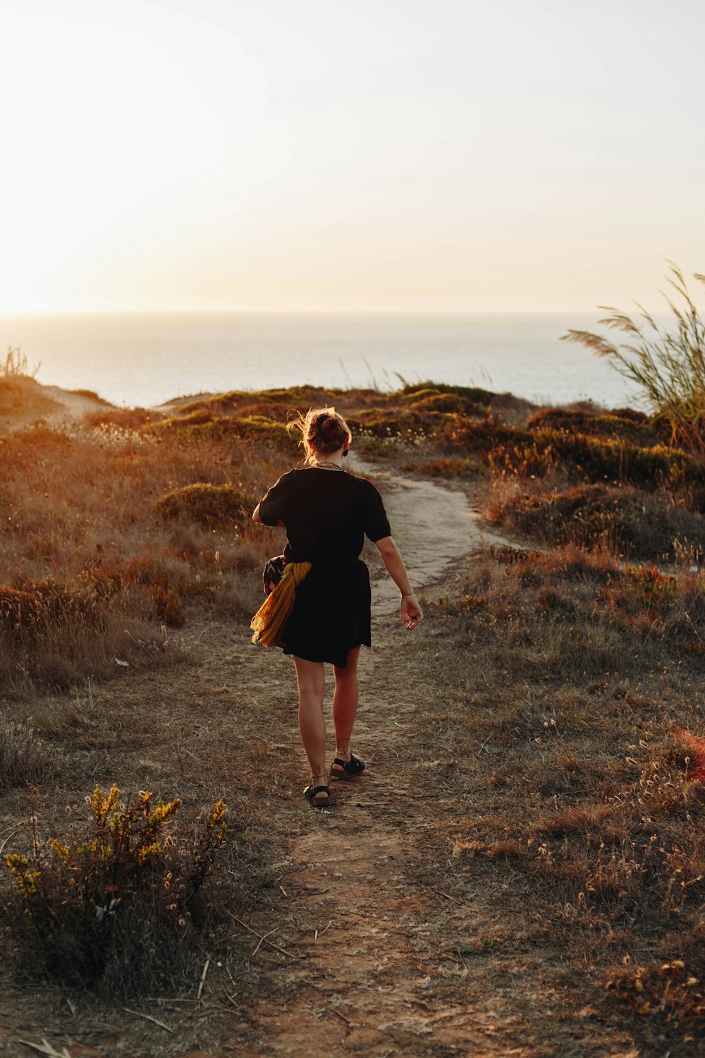 woman walking front of sea during daytime