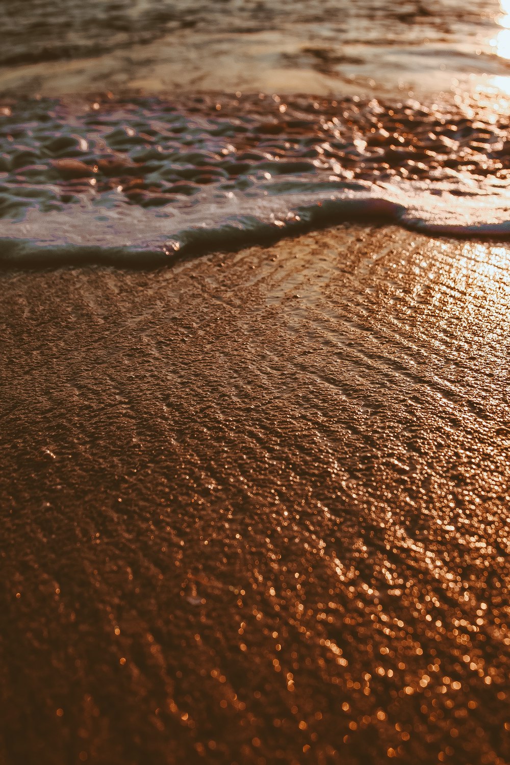 a close up of the sand and water on a beach