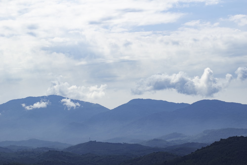 silhouette of mountains under cloudy sky