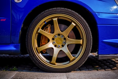 Close-up of a car's tires and brakes being examined.