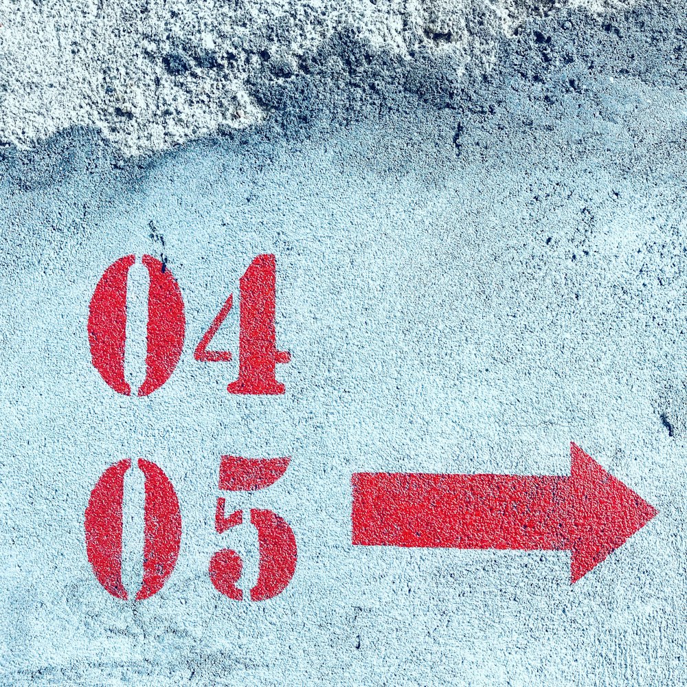 a red arrow pointing to the left on a concrete surface