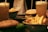 Two frothy beverages in tall glasses are placed alongside a burger with lettuce and tomato. A bowl of crispy fries is also visible, suggesting a casual dining scenario.