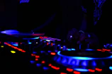 A futuristic DJ console glowing with electric blue and gold lights playing bachata beats.