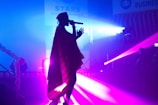 person performing on stage while using microphone