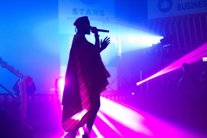 person performing on stage while using microphone