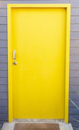 Close-up of a freshly painted front door with a welcome mat in a residential unit.