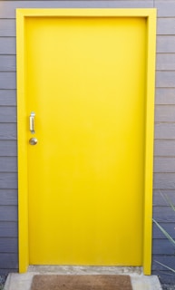 Close-up of a freshly painted front door with a welcome mat, symbolizing care in property management