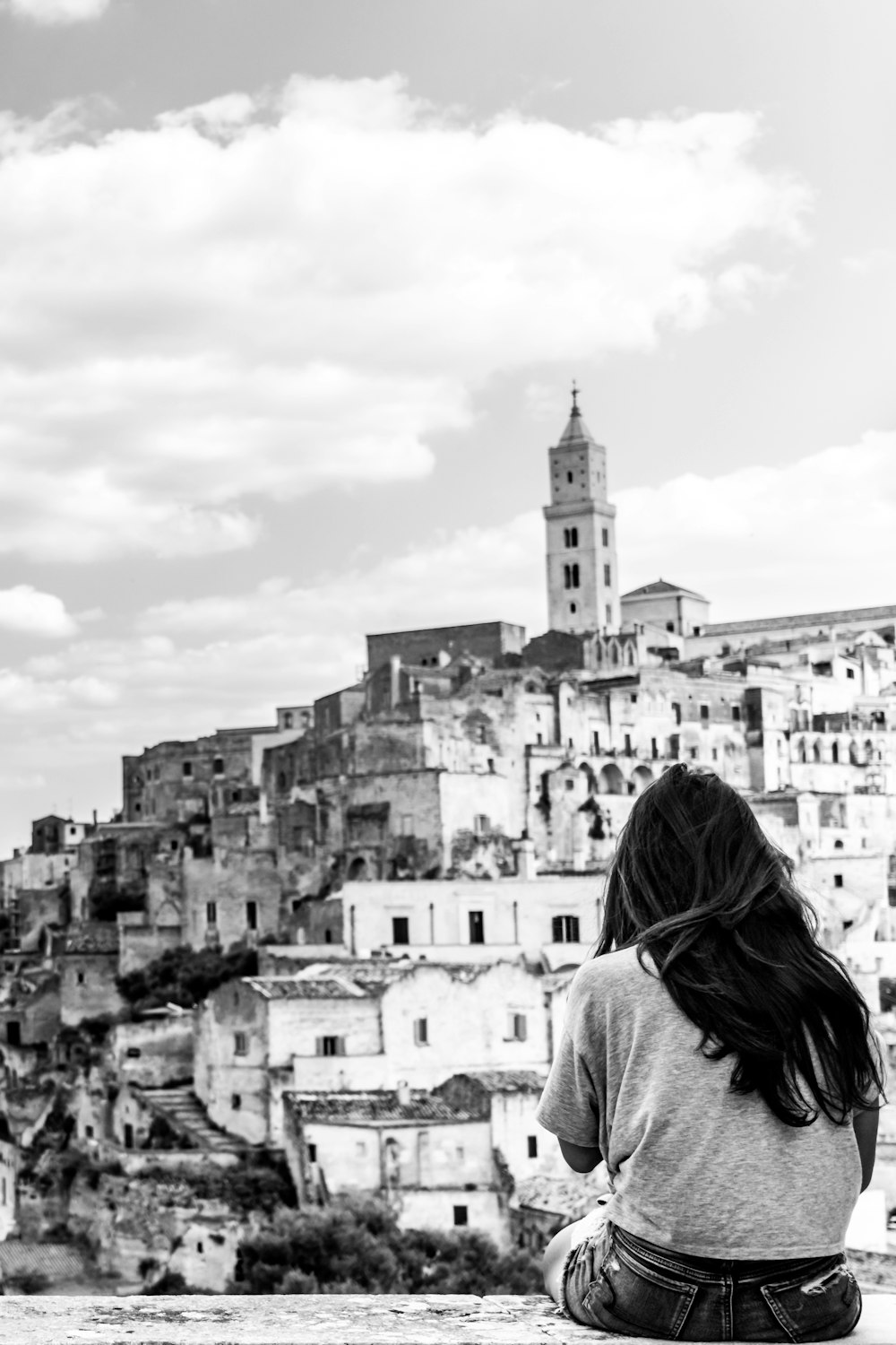 grayscale photo of woman looking at cathedral