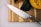 A sharp kitchen knife with a shiny blade and a metallic handle is placed on a wooden cutting board. Beside it, there are sliced and whole squash, showcasing their orange and green outer skins.