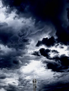 A weather station console displaying live data with storm clouds gathering in the background.