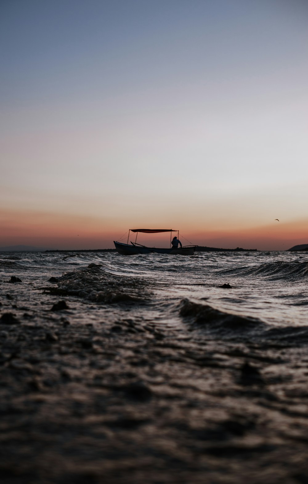 person riding on boat under gray sky