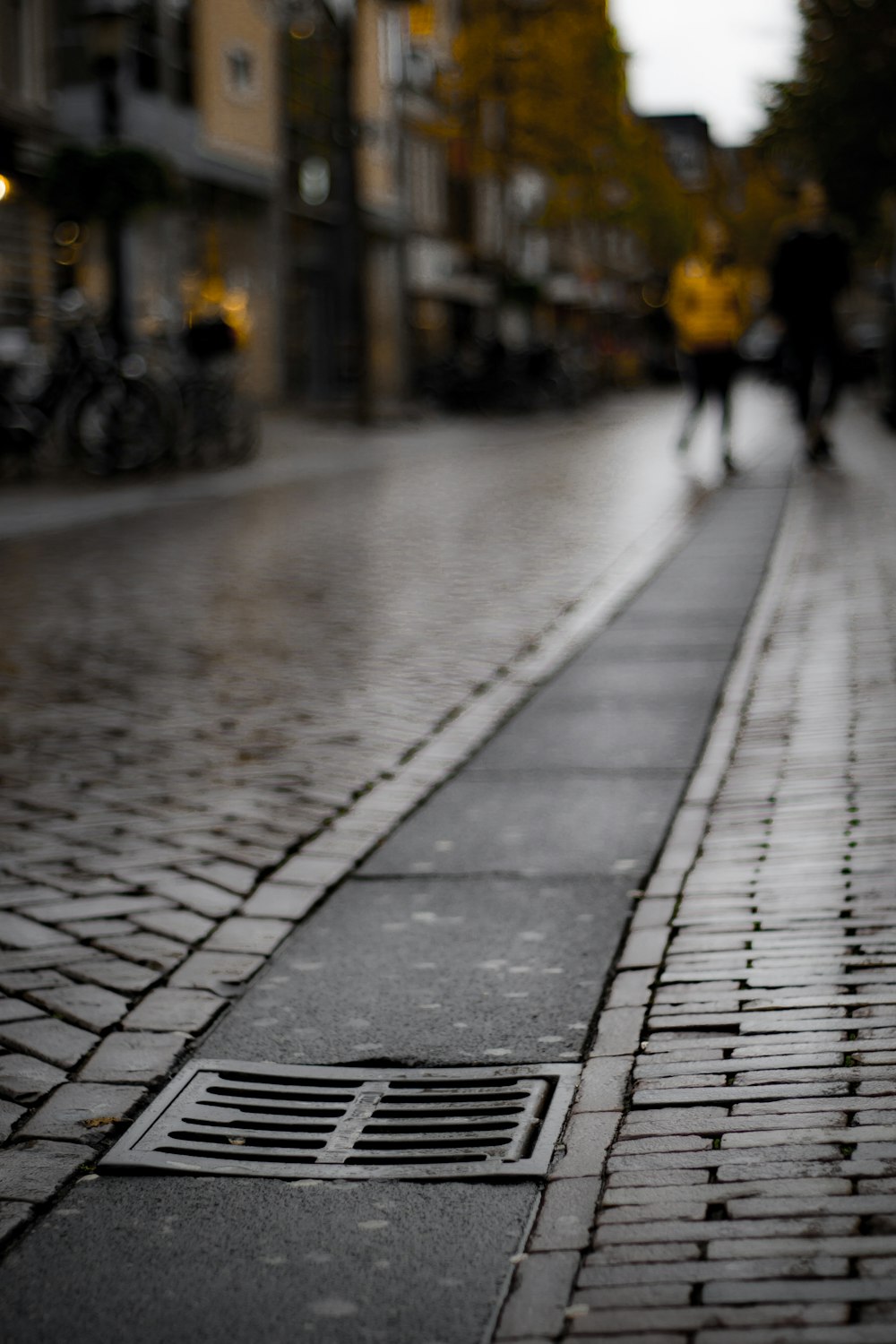 a brick sidewalk with people walking on it