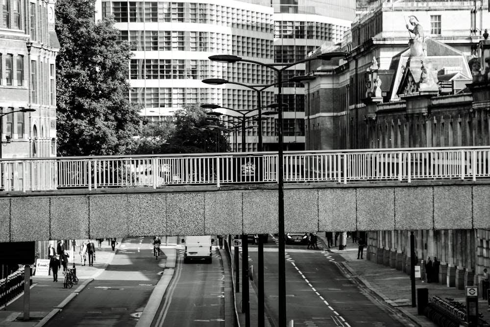 grayscale photo bridge and city buildings