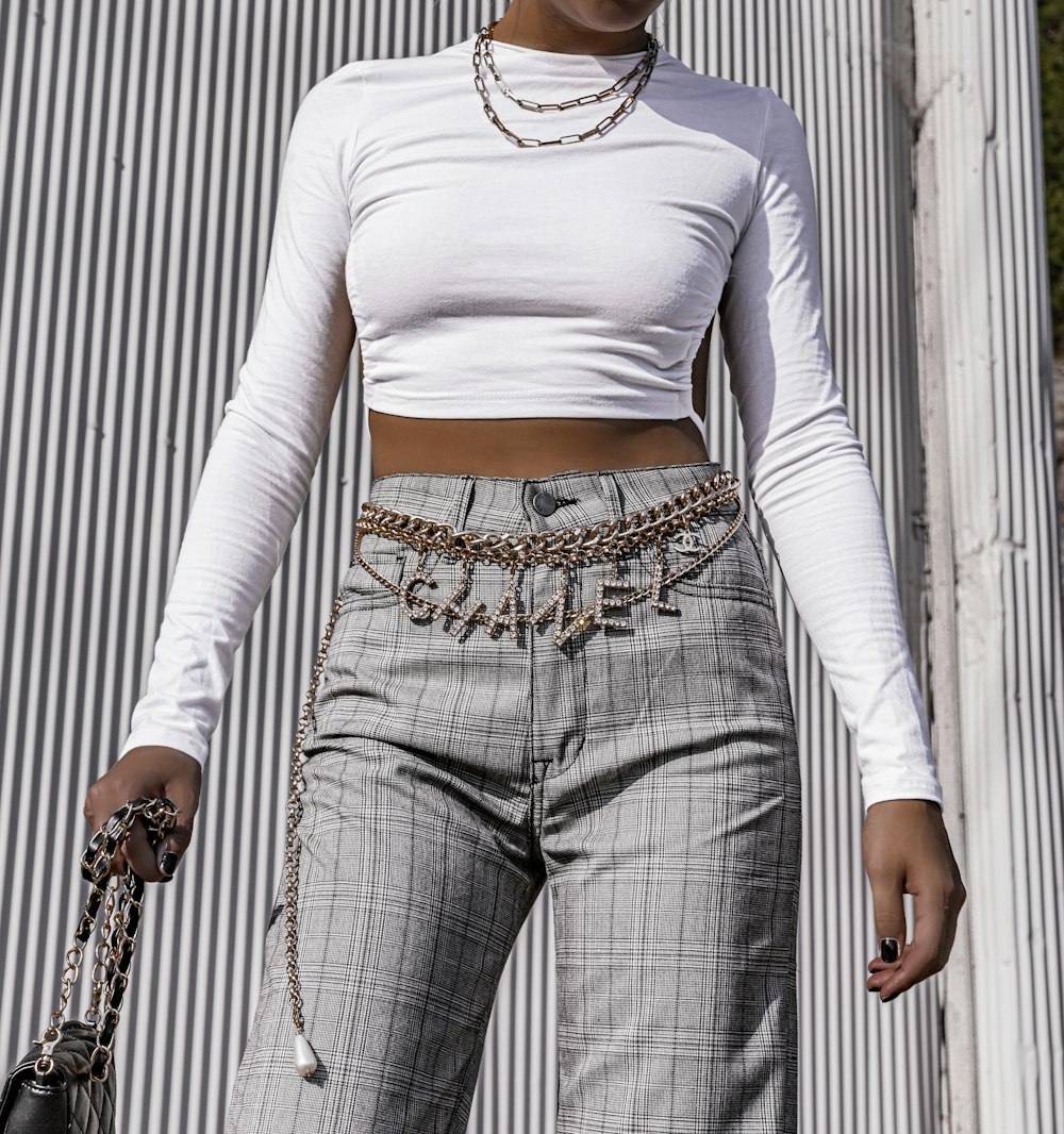 woman wearing white long-sleeved crop-top and grey pants