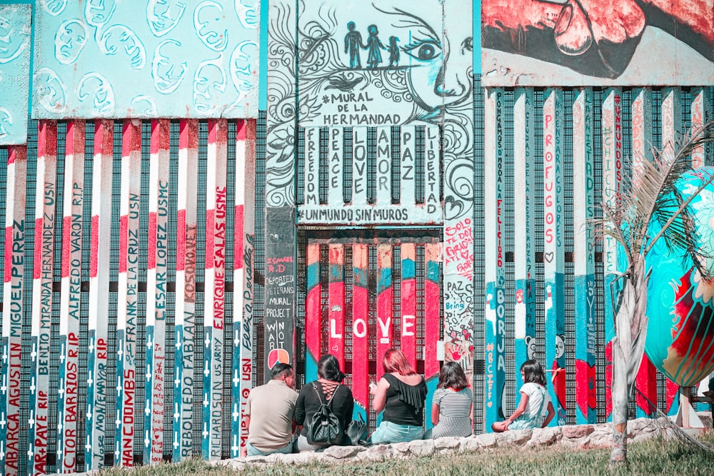 a group of people sitting on a bench in front of a building