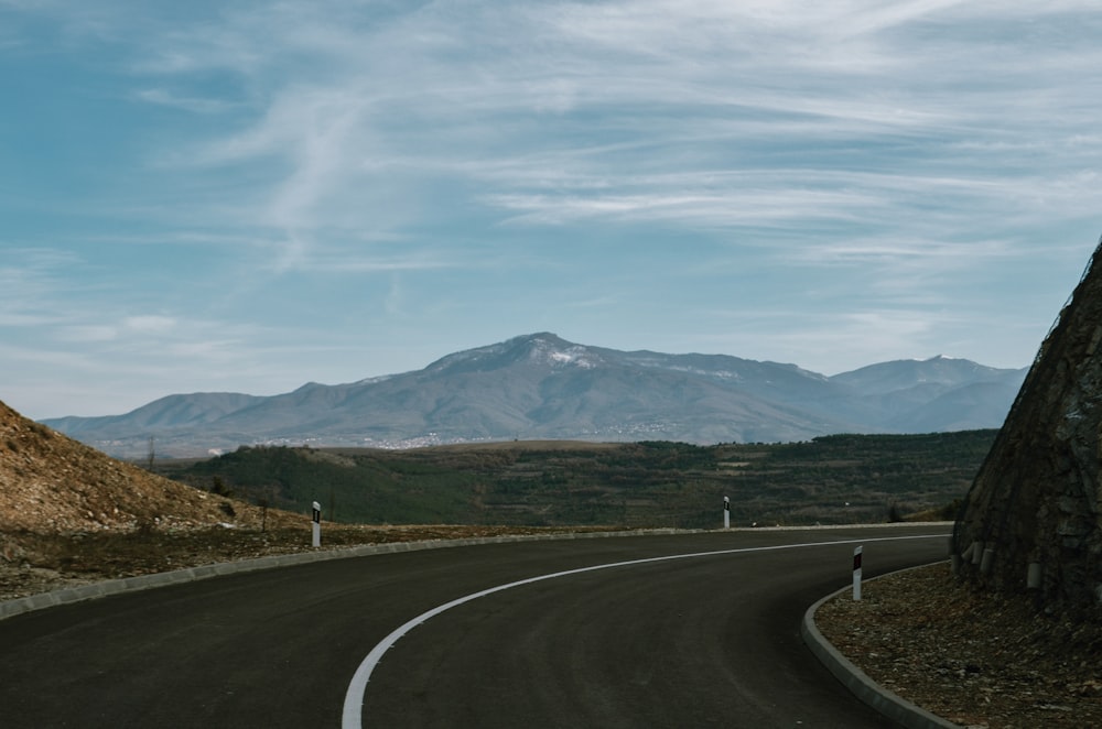 gray roadway between mountain during daytime