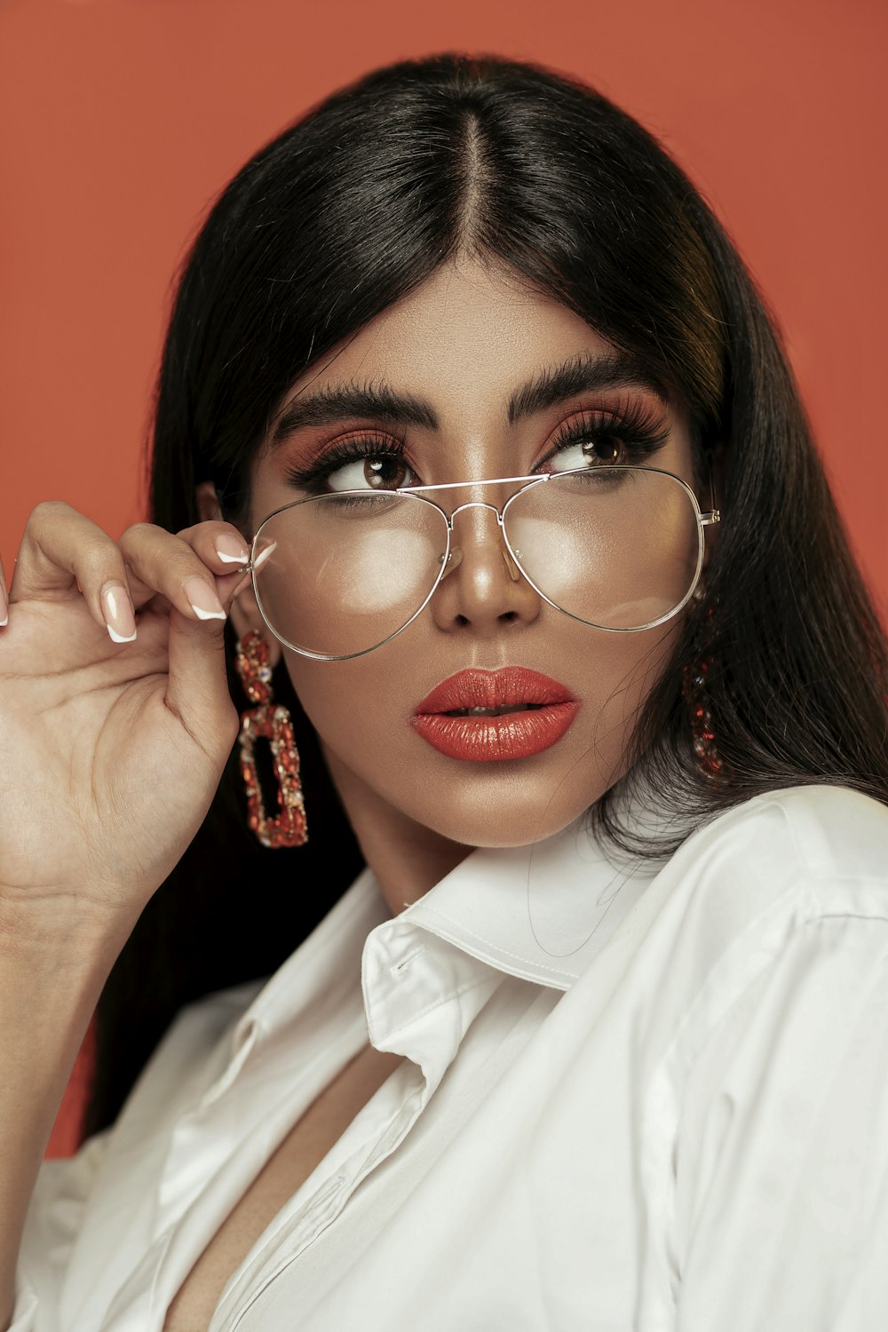 portrait of woman wearing aviator sunglasses and white collared top