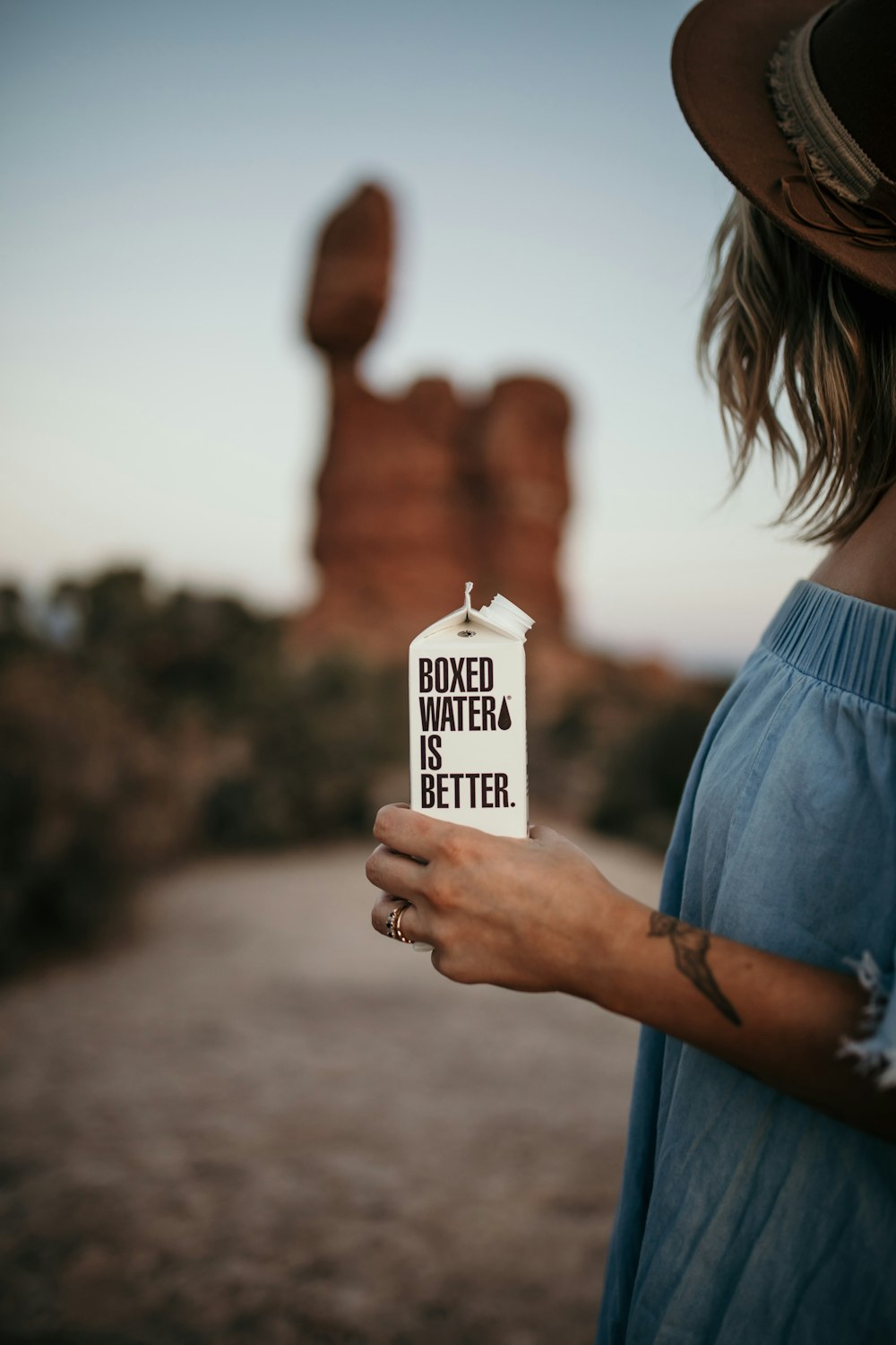 a woman holding up a sign that says loved water is better
