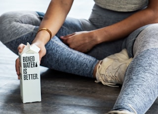 woman sitting on floor holding carton box