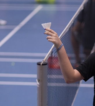 person holding white shuttlecock